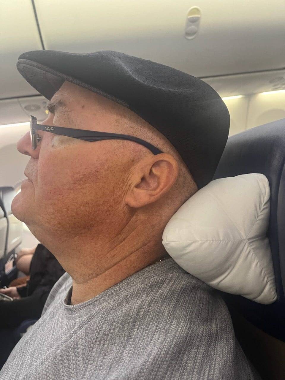 The neck-o pillow being using on an airplane as a neck pillow for optimal comfort in flight