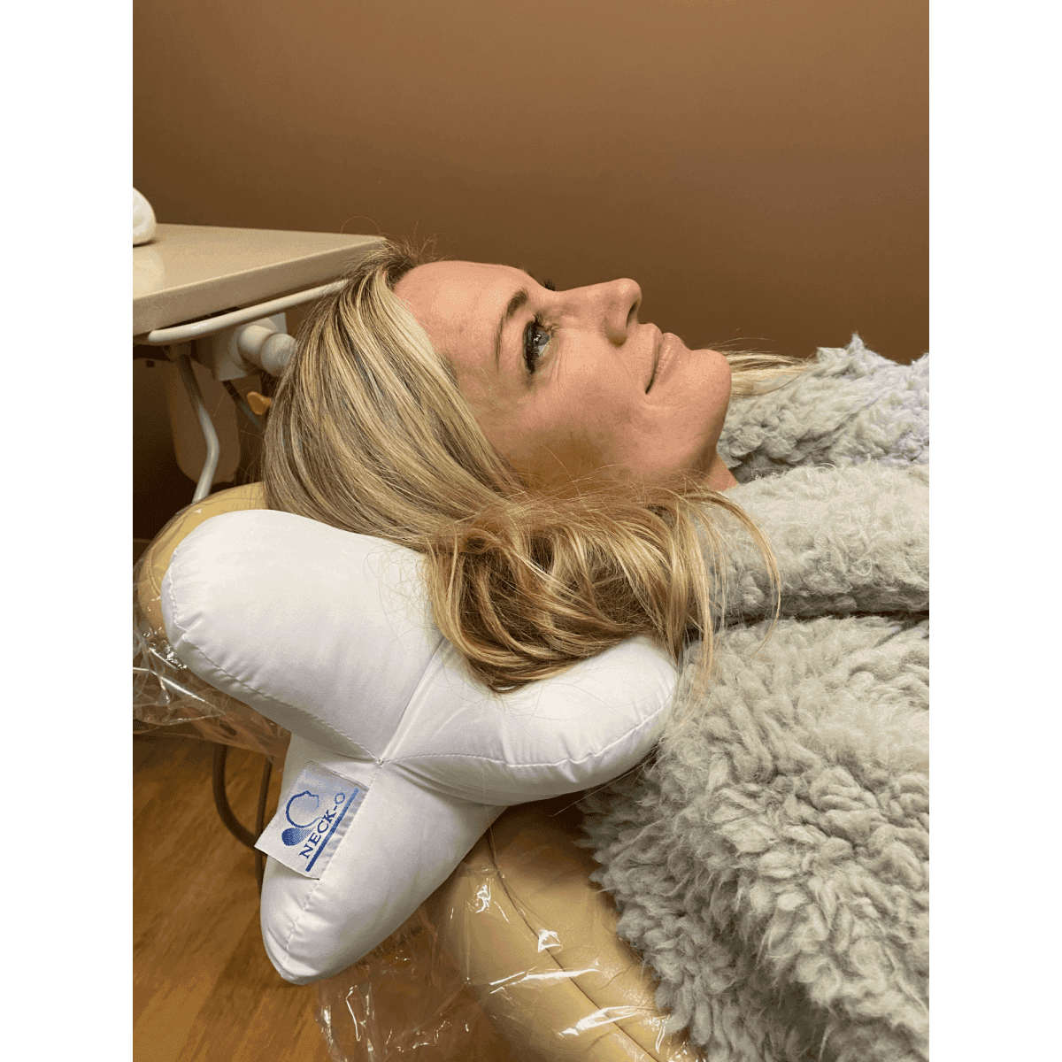 A customer using the neck-o pillow to combat neck pain while at the dentist