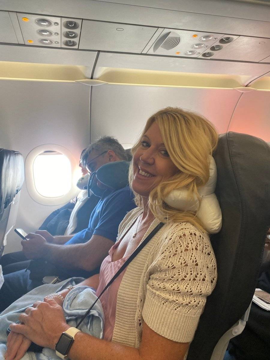 The neck-o pillow being using on an airplane as a neck pillow for optimal comfort in flight