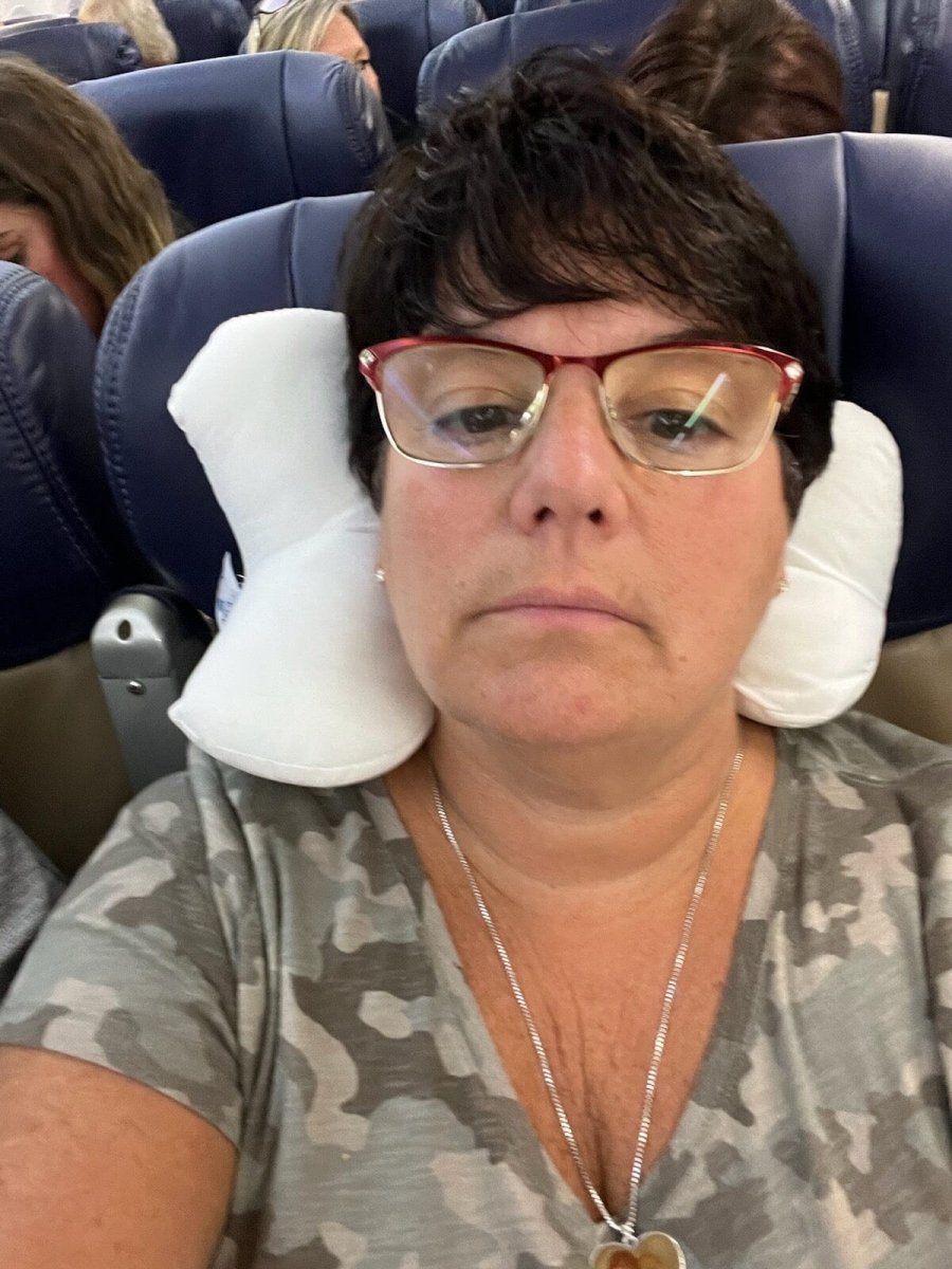 The neck-o pillow being using on an airplane as a neck pillow for optimal comfort in flight